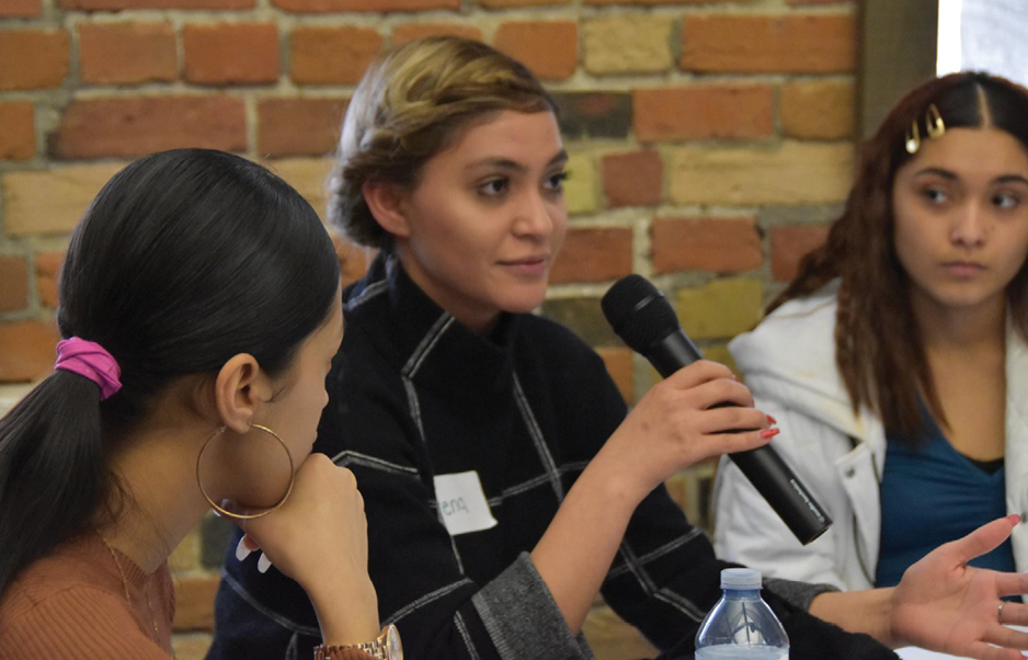 young women at a table speaking