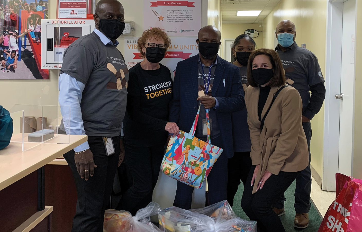 TNG staff and staff from GE African Affinity Forum standing with gift bag donations 