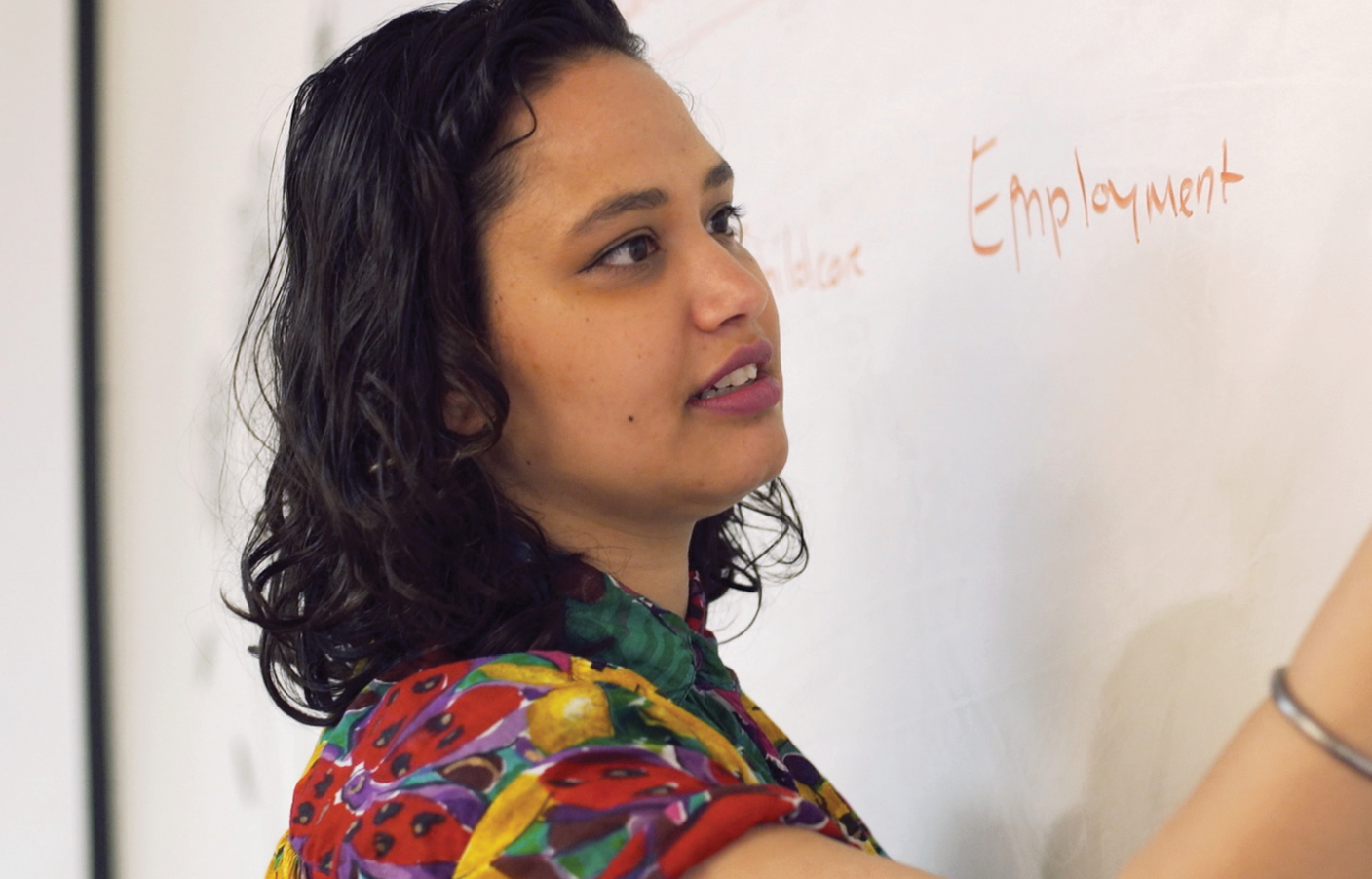 woman writing on white board