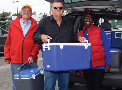 Meals on Wheels volunteers taking food out of the car