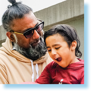 man holding smiling son with mother looking at them