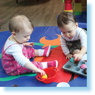 twin toddlers playing in child care room