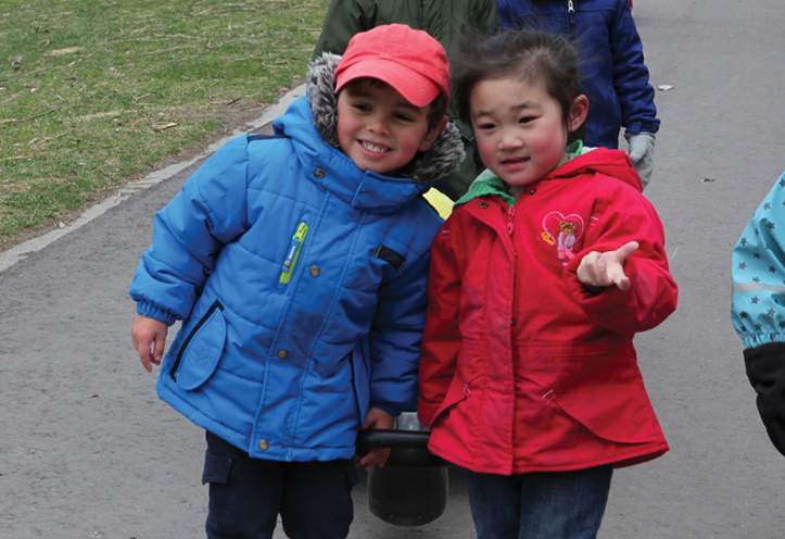 Two children, smiling, and posing for photo