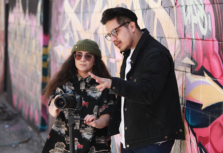 Woman standing behind camera wit man standing next to her