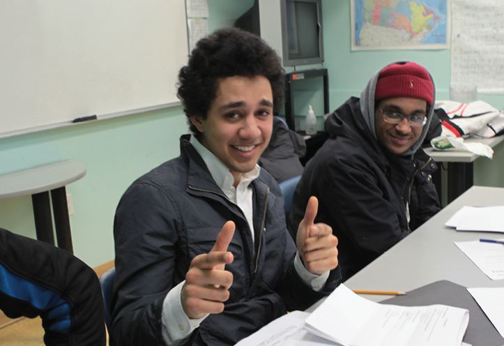 young man smiling and giving a thumbs up