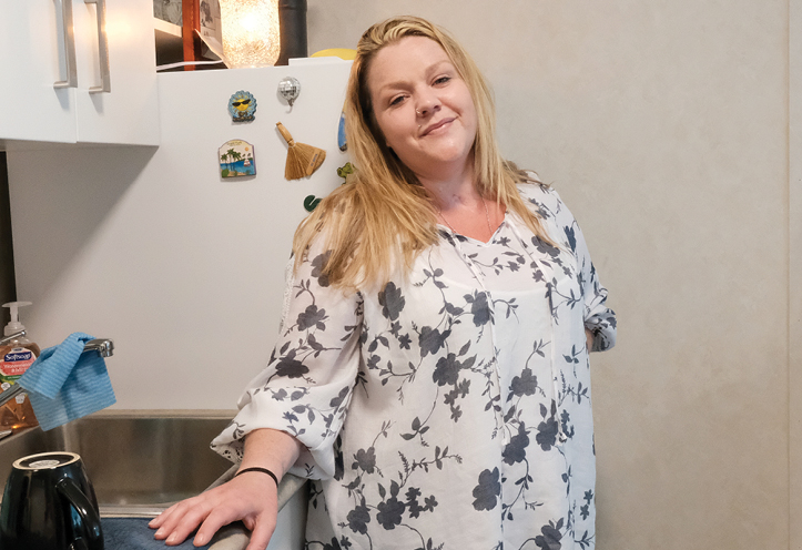 Woman standing in a kitchen smiling