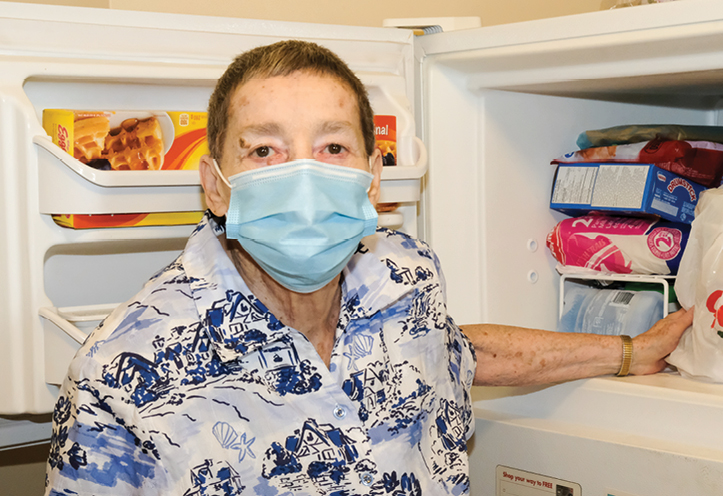 Woman standing in front of a fridge with its door open