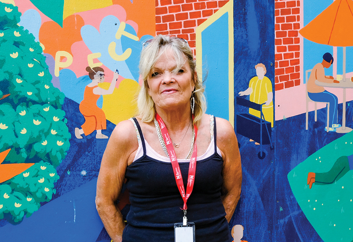 Woman standing in front of a mural, smiling