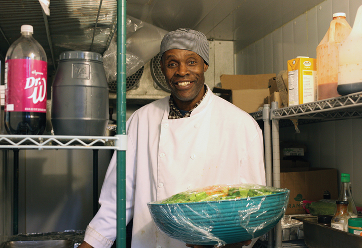 Man standing in kitchen holding a salad bowl