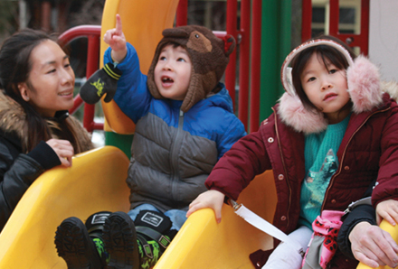 Mother and children playing at the Bellevue Ave. Child Care Centre playground