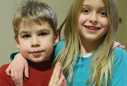 girl with arm around younger boy