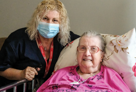 Personal support worker helping an elderly woman in her home