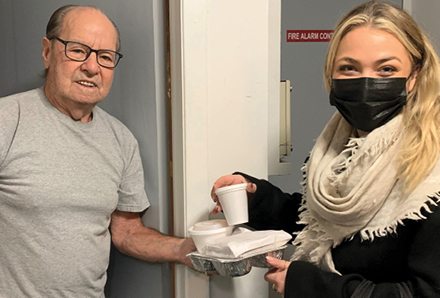 volunteer delivering a meal to a senior