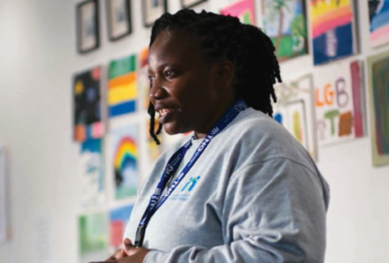 woman standing in front of a wall with colourful pictures