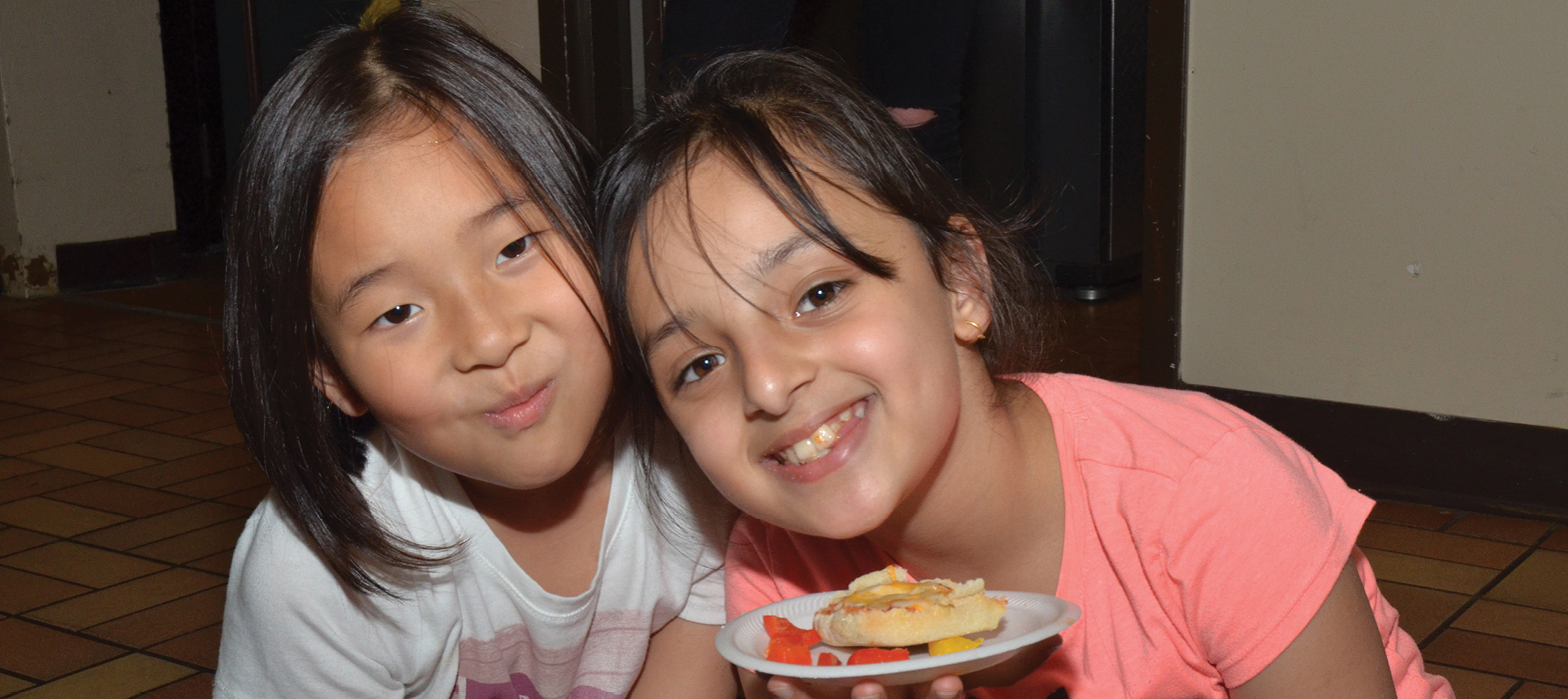 two young girls with a plate of snacks