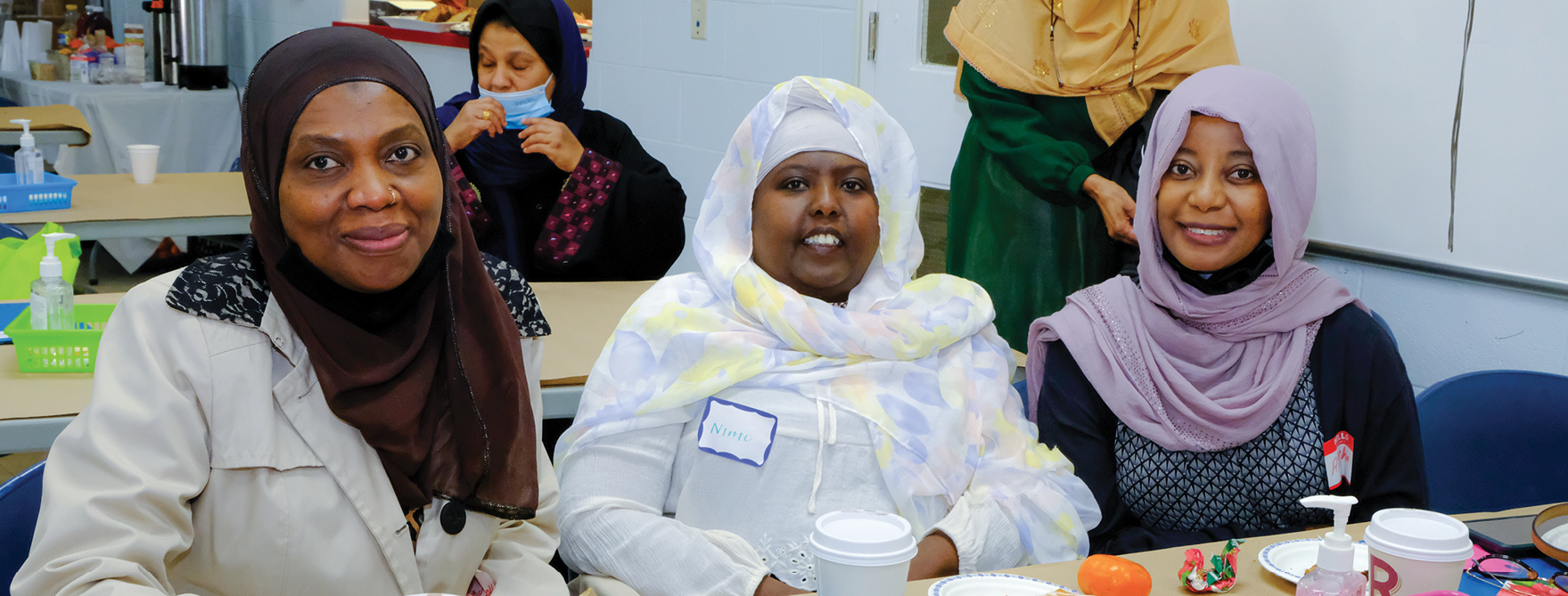 three smiling women sitting during lunch